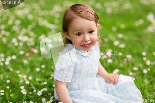 Image of happy baby girl on green summer field