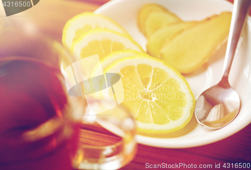 Image of tea cup with lemon and ginger on plate