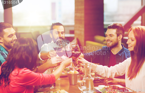 Image of friends dining and drinking wine at restaurant