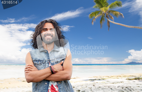 Image of smiling hippie man in denim vest on summer beach