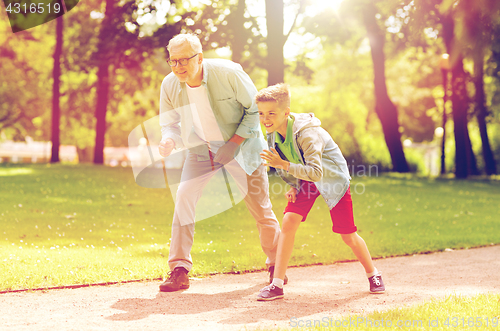 Image of grandfather and grandson racing at summer park