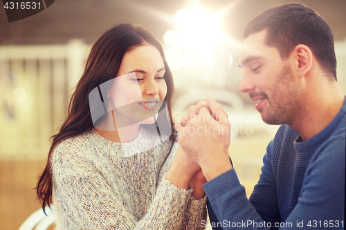 Image of happy couple holding hands at restaurant or cafe