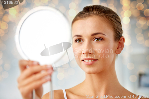 Image of beautiful woman looking to mirror at home