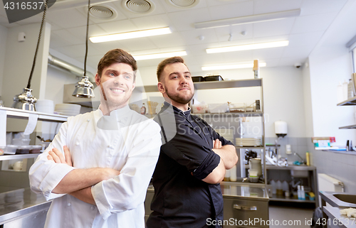 Image of happy smiling chef and cook at restaurant kitchen