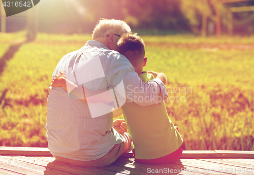 Image of grandfather and grandson hugging on berth