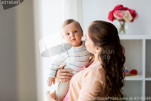 Image of happy young mother with little baby at home
