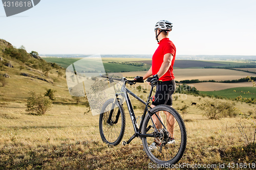 Image of portrait of young cyclist with his mountain bike bicycle outdoors