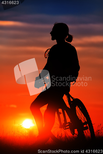 Image of Silhouette of a bike on sky background