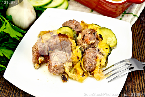 Image of Meatballs with cheese and squash in plate on dark board