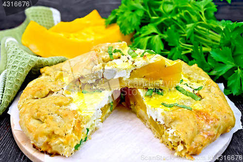 Image of Pie of pumpkin and cheese on dark board