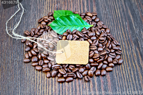 Image of Coffee black grain with tag and leaf on board