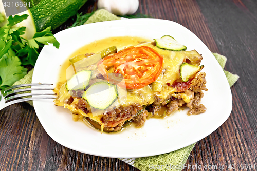 Image of Casserole from minced meat and zucchini in plate on board