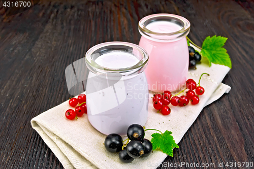 Image of Milk cocktail with black and red currant on dark board