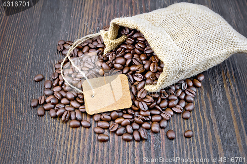 Image of Coffee black grain with tag in bag on dark board