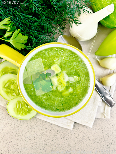 Image of Soup cucumber in yellow bowl on stone table top