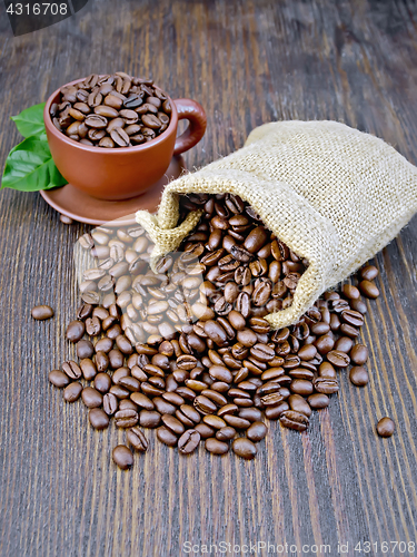 Image of Coffee black grains in bag with cup on dark board