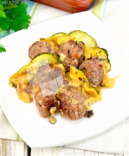 Image of Meatballs with zucchini and cheese in plate on light board