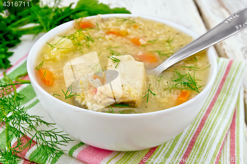 Image of Soup fish with millet and spoon on board