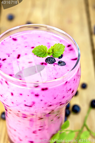 Image of Milkshake with blueberries in glass on table