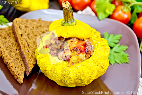 Image of Squash yellow stuffed with meat on dark board