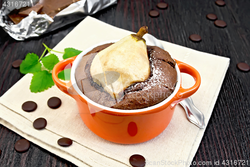 Image of Cake with chocolate and pear in red bowl on towel