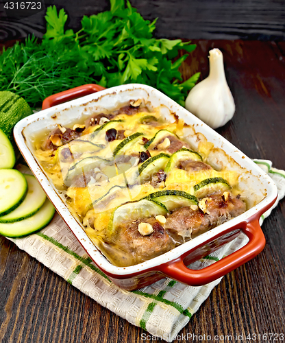 Image of Meatballs with zucchini and nuts in brazier on dark board