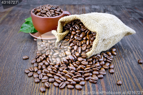 Image of Coffee black grains in bag with cup on board