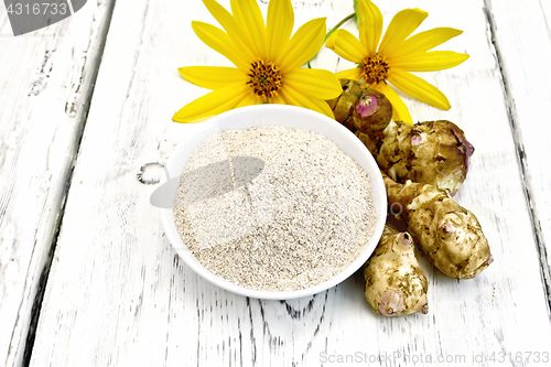 Image of Flour of Jerusalem artichoke in bowl with flower on light  board