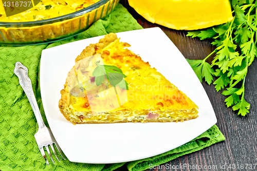 Image of Quiche with pumpkin and bacon in plate on dark board