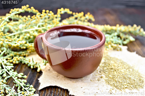 Image of Tea with wormwood in brown cup on table