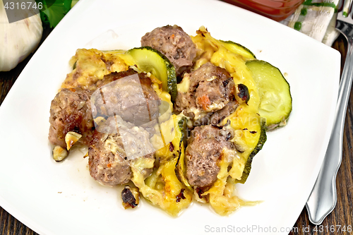 Image of Meatballs with zucchini and cheese in plate on dark board