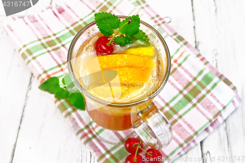 Image of Lemonade with cherry and orange in wineglass on light board