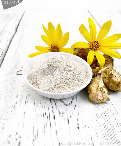 Image of Flour of Jerusalem artichoke in white bowl with flower on board