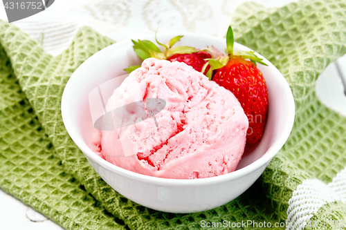 Image of Ice cream strawberry with berries in bowl on green napkin