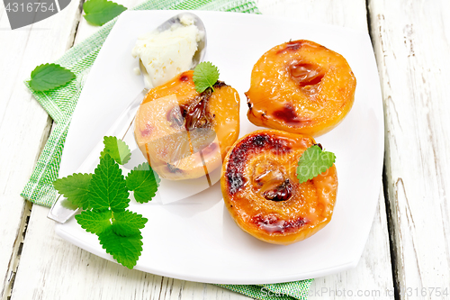 Image of Quince baked with ice-cream and mint in plate on board