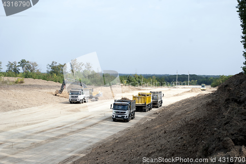 Image of road construction dump trucks excavator