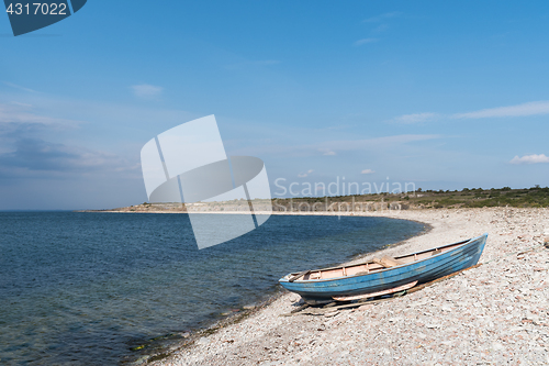 Image of Blue rowing boat by seaside