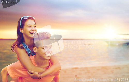 Image of happy teenage couple having fun on beach