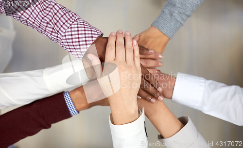 Image of business team with hands on top at office