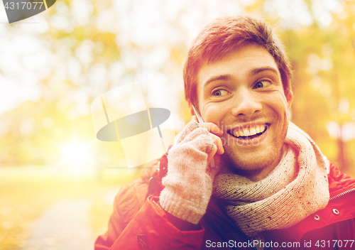 Image of man with smartphone calling on city street