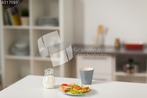 Image of sandwiches with coffee and cream at home kitchen