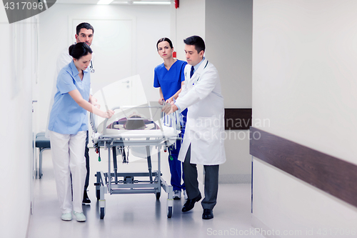 Image of medics with woman on hospital gurney at emergency