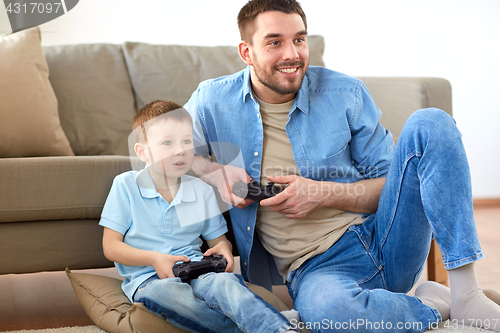 Image of father and son playing video game at home