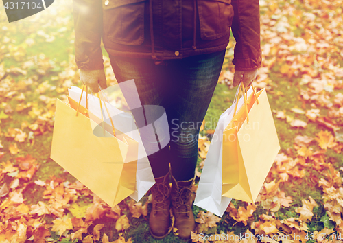 Image of woman with shopping bags in autumn park