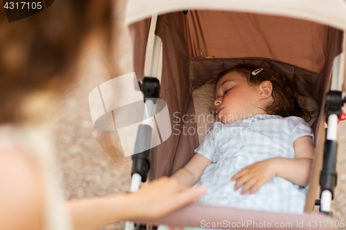 Image of mother with child sleeping in stroller