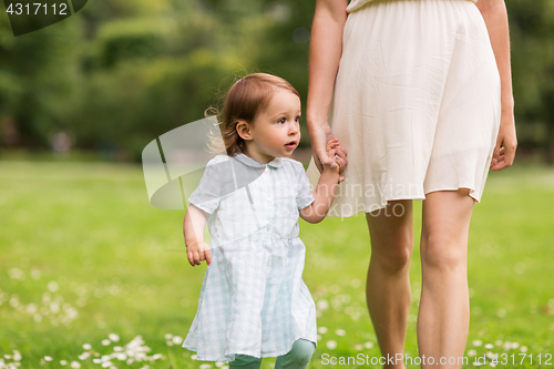 Image of mother with baby girl walking at summer park