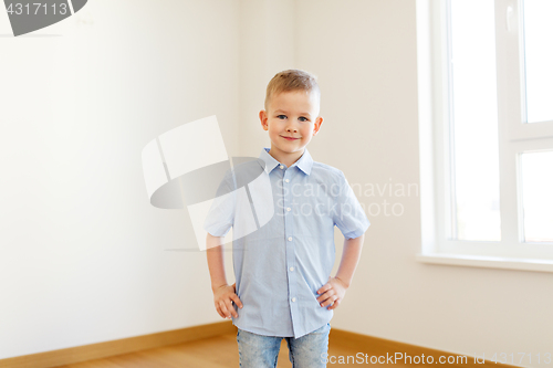 Image of smiling little boy at empty room of new home