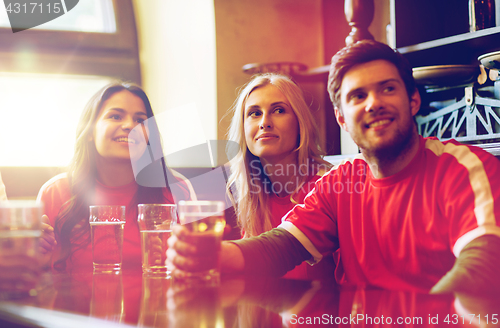 Image of fans or friends watching football at sport bar