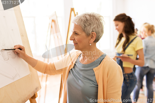 Image of woman artist with pencil drawing at art school