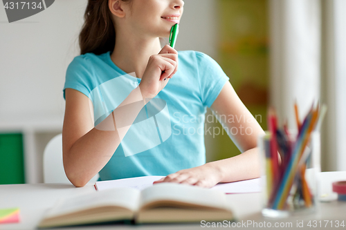 Image of happy girl with book and notebook dreaming at home